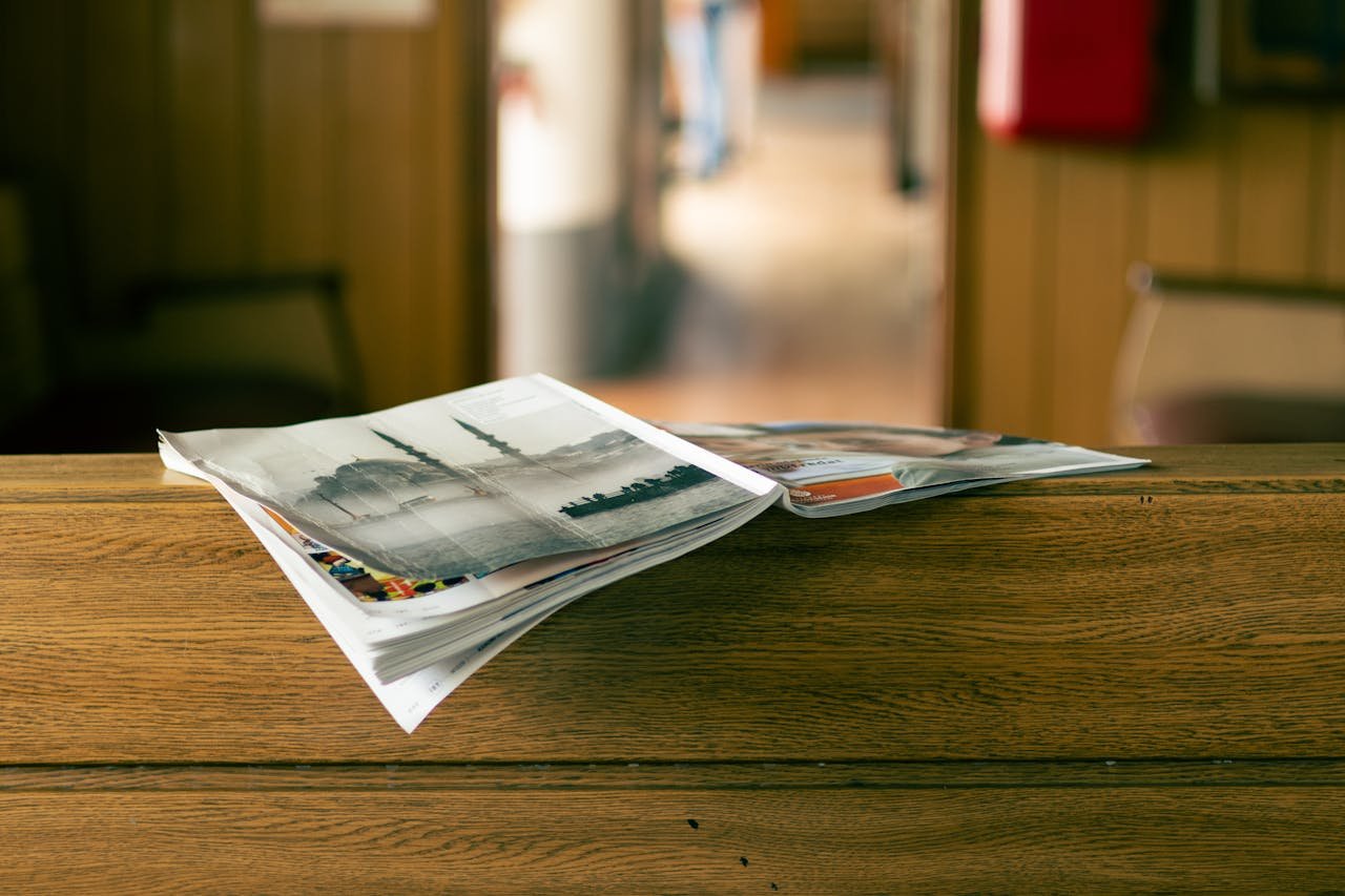 About Stack of magazines on a wooden table in a cozy indoor environment.
